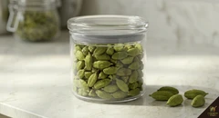 Green cardamom pods in airtight dark glass jar