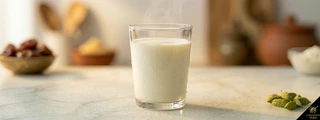 Glass of whole milk with green cardamom pods — milk cardamom pairing chai kheer kulfi doodh elaichi